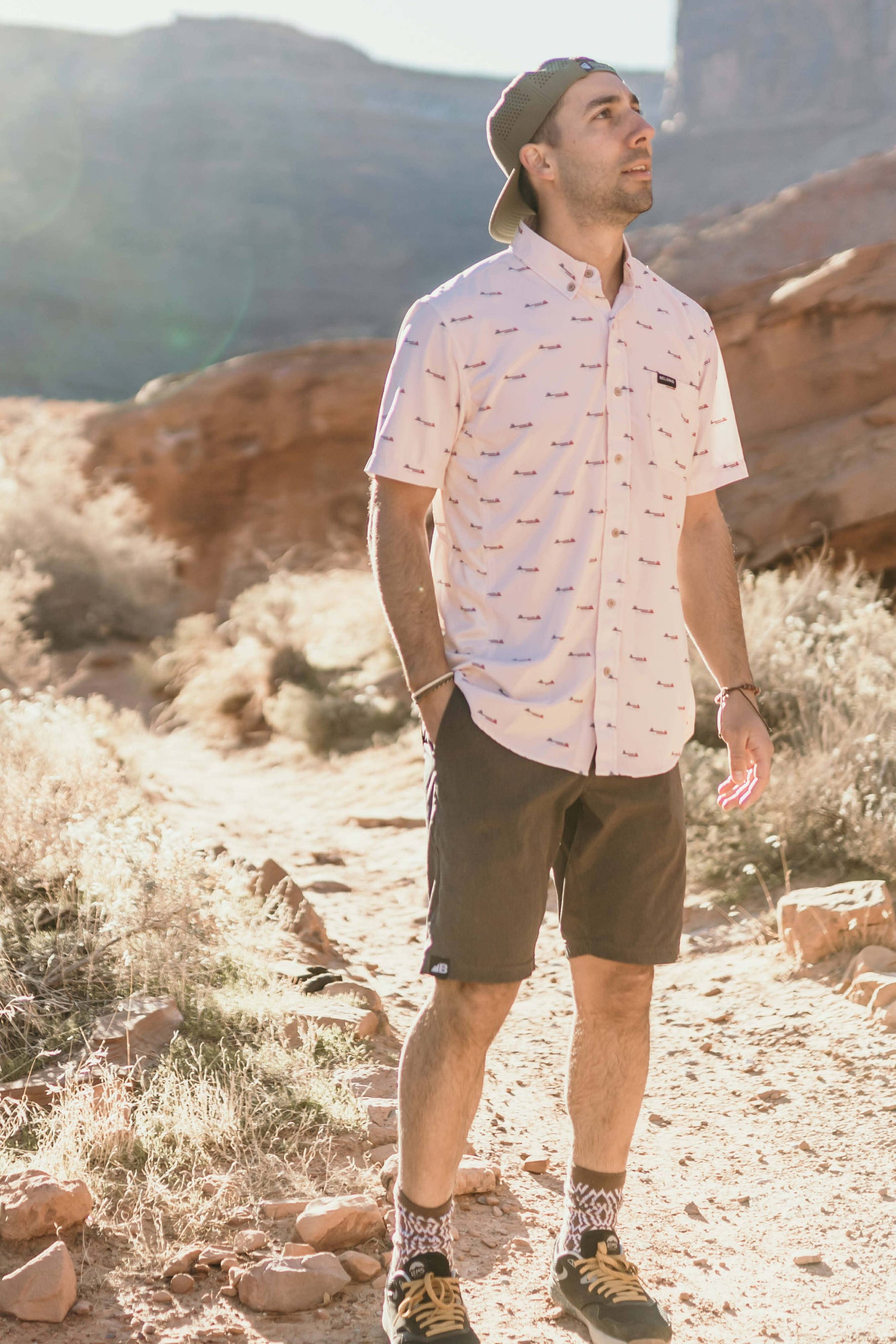 The Vista Stretch Button Down from Belong Designs features a modern, casual design in Summit Teal. This short-sleeve shirt includes a buttoned-down collar and is crafted from wrinkle-resistant fabric. It also comes with a small chest pocket adorned with a logo patch reading "Belong Designs.