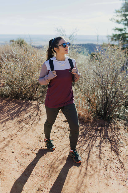 A person wearing Belong Designs' Rocky Mountain Joggers, crafted from durable and stretchy material, stands against a plain background. They are dressed in a dark green cropped top paired with matching athletic pants featuring a drawstring, complemented by brown hiking boots with teal laces. The image is cropped to show the midriff down.
