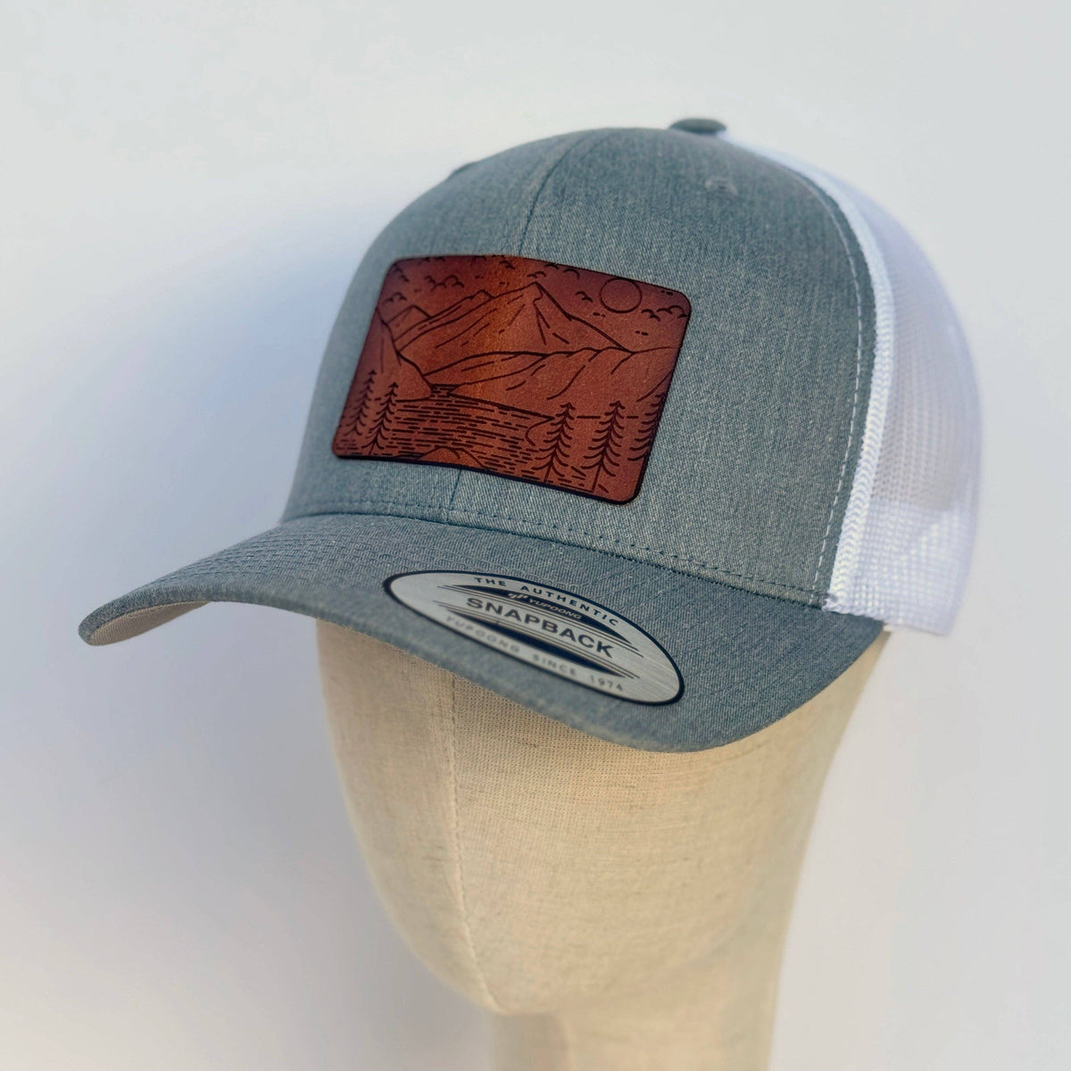 The Lonely Pine Rivers & Ridges | mountain scape leather patch hat gray white curved trucker
